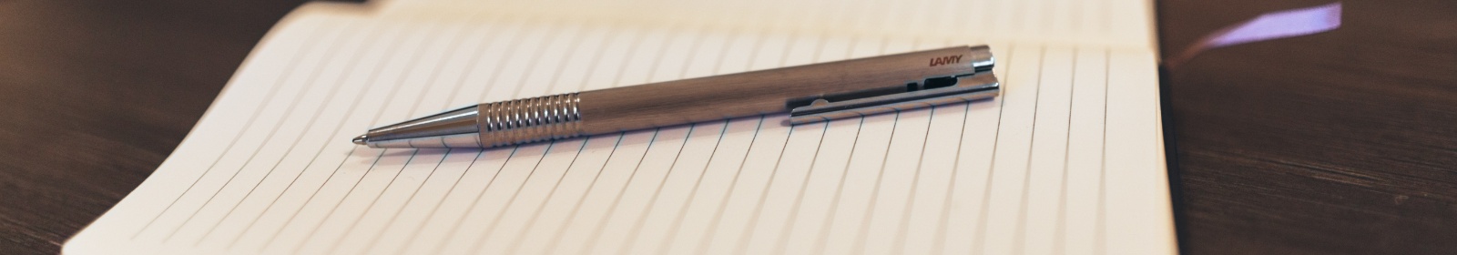 a pen on a writing pad